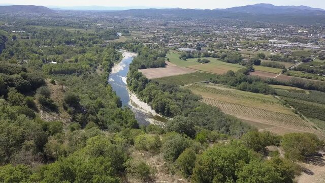 Cliff top aerial overlooks Aubenas and Ardeche River in rural France