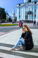 A young woman in front of the Trinity-Sergius Lavra in Sergiev Posad. Moscow region. Russia. came out