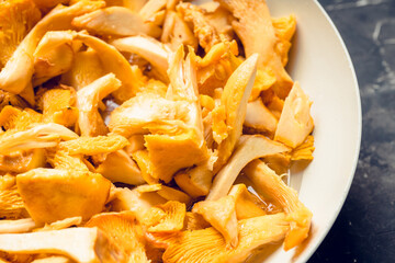 Sliced chanterelle mushrooms on the pan, ready for frying. Selective focus. Shallow depth of field. 