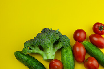 Fresh juicy vegetables on a bright yellow background. Raw food and vegetarianism photo with place for text.