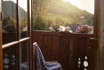 reading a book on a balcony overlooking the alps