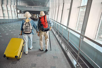Fototapeta na wymiar Elderly tourist couple going along the airport terminal