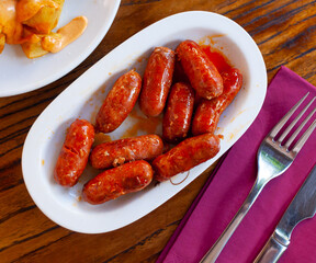 Spanish appetizer, warm mini chorizo sausages choricitos de Navarra in ceramic bowl