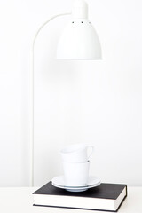 pile of teacups and desk lamp