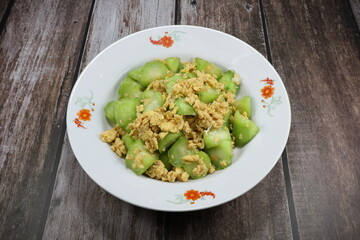 Fried and stirred cutting fresh zucchini with chicken egg and seasoning with oyster sauce and pepper on the plate. Famous traditional vegetarian menu in Asia restaurant. High fiber and protein food.