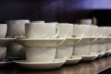 White mugs with saucers for tea and coffee in a cafe.