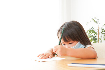 マスクを付けて勉強をする子供と塾講師