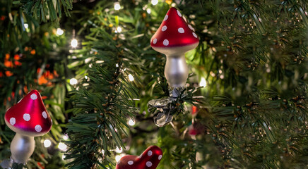 Glass mushrooms - amanita - Christmas tree toy on a branch of green spruce