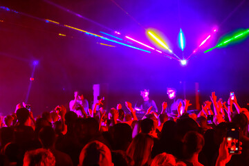 Fototapeta na wymiar Crowd and DJs dancing during party