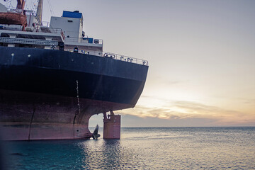 Gelendzhik, Kabardinka, Russia. Cargo ship "Rio" ran aground on coast after a storm in the black sea at sunset. View stern of the vessel.