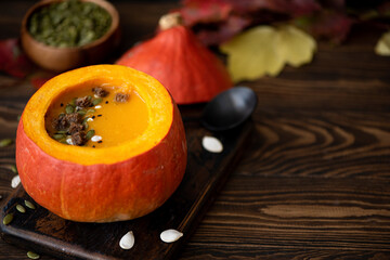 pumpkin puree soup in pumpkin with seeds and sesame seeds