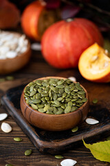 peeled dried pumpkin seeds in a wooden bowl