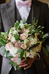 A groom holding beautiful wedding bouquet closeup