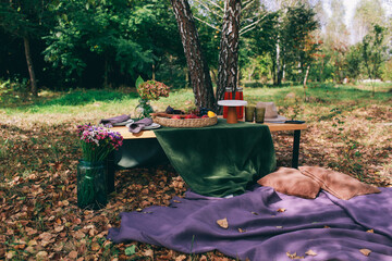 Outdoor Gender Reveal Party Decorations. girl or boy. beautiful photo zone with cake and fruits.
autumn decor with purple and green color. Two glasses of the red wine and tasty food and accessories 