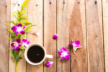 hot coffee espresso with purple flowers orchids arrangement flat lay style on background wooden