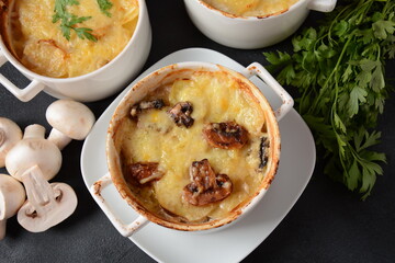 Potato gratin with mushrooms in baking cocottes