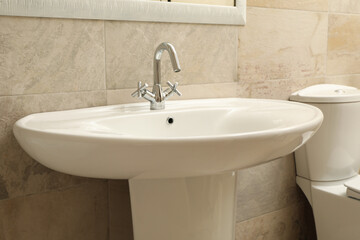 Sink in modern comfortable bathroom in light beige color