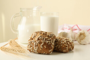 Fresh baked garlic buns and milk on white table
