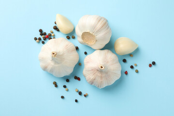Raw garlic and peppercorn on blue background