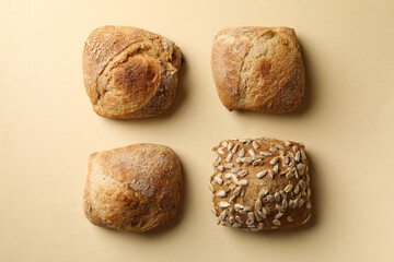 Fresh baked buns on beige background, top view