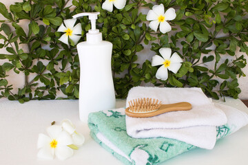 natural herbal liquid soap and terry cloth for a bath health care body skin of lifestyle woman with flower frangipani arrangement flat lay style on background wooden