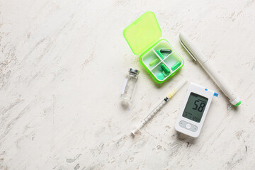 Glucometer with lancet pen, medications and syringe on white background. Diabetes concept