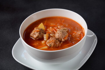 Patatesli Sulu Kofte - Turkish soup with meatballs in white bowl.