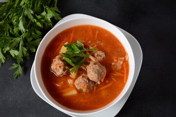 Patatesli Sulu Kofte - Turkish soup with meatballs in white bowl.