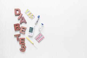 Glucometer with lancet pen, medications, syringe and word DIABETES on white background