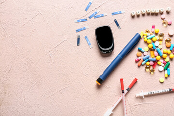 Glucometer with test strips, pills, syringes and word DIABETES on color background