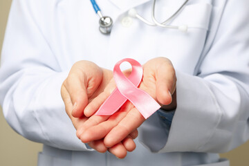 Doctor hold pink awareness ribbon, close up