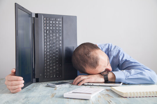 Businessman Sleeping At Desk In Office.