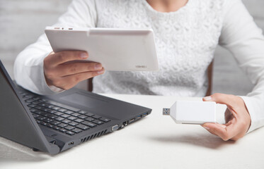 Girl hands holding usb flash drive and tablet.