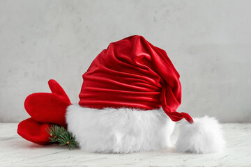 Santa hat and mittens on light background