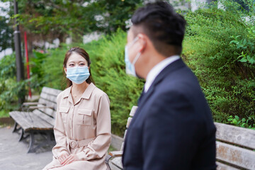 ソーシャルディスタンスを確保して会話をするビジネスパーソン