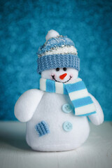 Snowman toy on blue background. New Year decoration