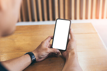 cell phone mockup blank white screen.man hand holding texting using mobile on desk at coffee shop.background empty space for advertise.work people contact marketing business,technology
