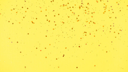 Gold glitter on yellow background. Holiday abstract
