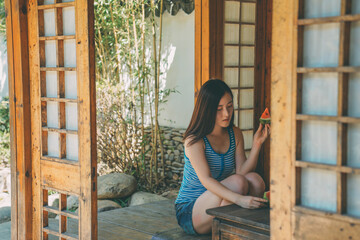 Fototapeta premium Summer watermelon and sweet girl in Japanese Garden