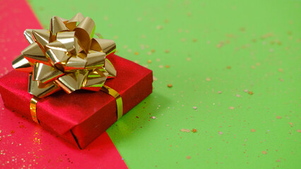 Gift or present box and confetti on red and green backgraund.