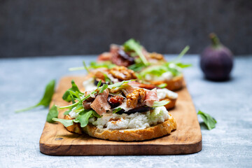 Canapes with ricotta cheese, figs, walnuts and parma ham