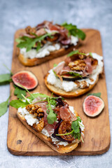 Canapes with ricotta cheese, figs, walnuts and parma ham