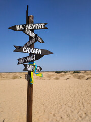 Signpost in the middle of a desert in midday under the  scorching sun