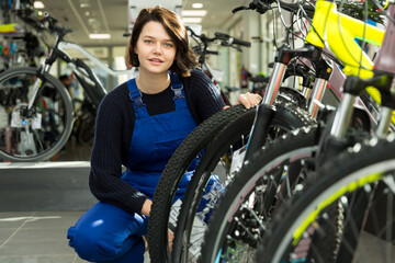 Fototapeta na wymiar Cheerful professional woman standing in bicycle shop
