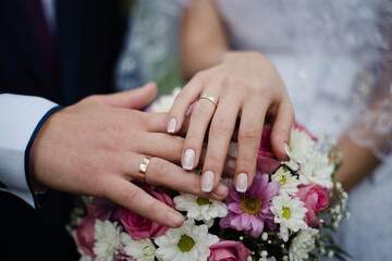 Obraz na płótnie Canvas hands of bride and groom, bride and groom, hands with wedding rings, bouquet with bride