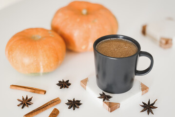 Spicy coffee with cinnamon, star anise and pumpkin in a black mug