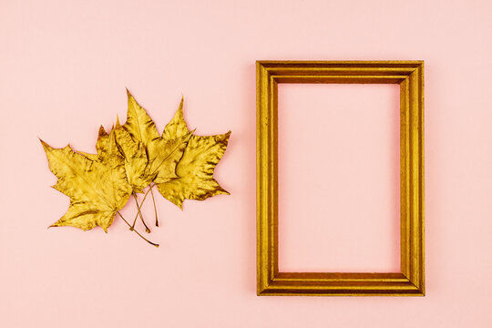 Autumn bouquet of golden painted maple leaves on pink background. Trendy concept. Flay lay in minimalism style.