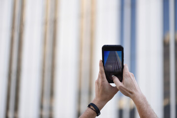 Man's hands capturing an urban photograph with his digital device.