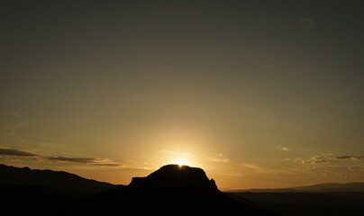 Sunset view behind the silhouettes of some low mountains in the Almer&iacute;a desert.