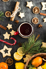 hot tea in a red mug in a new year's atmosphere. Christmas morning. A mug with a drink next to Christmas tree branches, oranges, spices and cookies
